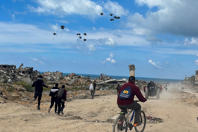 Warga Palestina bergegas menuju pantai untuk mengumpulkan bantuan yang dijatuhkan dari udara, di tengah konflik yang sedang berlangsung antara Israel dan Hamas, di Jalur Gaza utara, 25 Maret 2024. Warga Palestina bergegas menuju pantai untuk mengumpulkan bantuan yang dijatuhkan dari udara, di tengah konflik yang sedang berlangsung antara Israel dan Hamas, di Jalur Gaza utara, 25 Maret 2024. (REUTERS/Stringer)