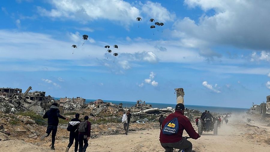 Warga Palestina bergegas menuju pantai untuk mengumpulkan bantuan yang dijatuhkan dari udara, di tengah konflik yang sedang berlangsung antara Israel dan Hamas, di Jalur Gaza utara, 25 Maret 2024. (REUTERS/Stringer)