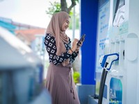 Pengguna kendaraan listrik yang menggunakan fitur Electric Vehicle pada aplikasi PLN Mobile untuk melakukan charging di SPKLU. (Dok: PT PLN (Persero)