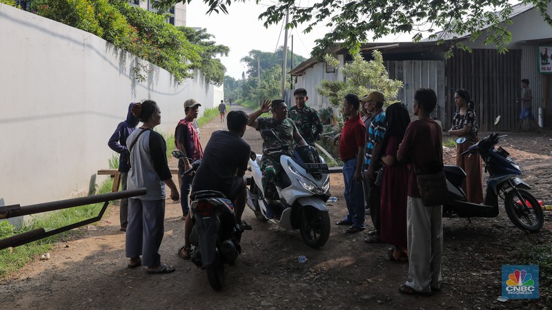 Anggota TNI berjaga pada akses masuk Kampung Parung Pinang, Kabupaten Bogor, Jawa Barat, Minggu (31/3/2024). Akibat adanya ledakan gudang amunisi Gudang Amunisi Daerah milik Batalyon Artileri Medan (Yonarmed) 07/155 GS Kodam Jaya warga Kampung Parung Pinang meninggalkan kediamannya. (CNBC Indonesia/Faisal Rahman)