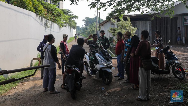 Anggota TNI berjaga pada akses masuk Kampung Parung Pinang, Kabupaten Bogor, Jawa Barat, Minggu (31/3/2024). Akibat adanya ledakan gudang amunisi Gudang Amunisi Daerah milik Batalyon Artileri Medan (Yonarmed) 07/155 GS Kodam Jaya warga Kampung Parung Pinang meninggalkan kediamannya. (CNBC Indonesia/Faisal Rahman)