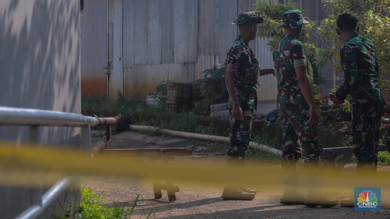 Anggota TNI berjaga pada akses masuk Kampung Parung Pinang, Kabupaten Bogor, Jawa Barat, Minggu (31/3/2024). Akibat adanya ledakan gudang amunisi Gudang Amunisi Daerah milik Batalyon Artileri Medan (Yonarmed) 07/155 GS Kodam Jaya warga Kampung Parung Pinang meninggalkan kediamannya. (CNBC Indonesia/Faisal Rahman)