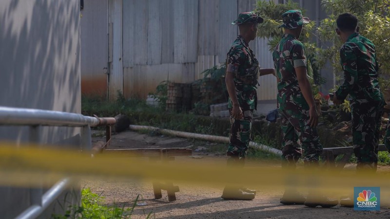 Anggota TNI berjaga pada akses masuk Kampung Parung Pinang, Kabupaten Bogor, Jawa Barat, Minggu (31/3/2024). Akibat adanya ledakan gudang amunisi Gudang Amunisi Daerah milik Batalyon Artileri Medan (Yonarmed) 07/155 GS Kodam Jaya warga Kampung Parung Pinang meninggalkan kediamannya. (CNBC Indonesia/Faisal Rahman)