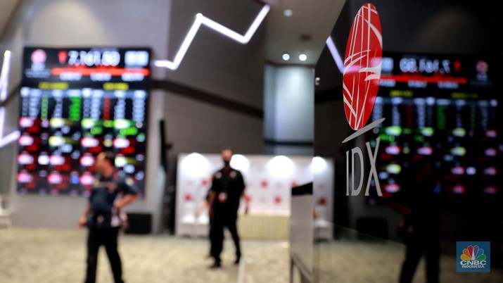 Pekerja melintas di depan layar Indeks Harga Saham Gabungan (IHSG) di Bursa Efek Indonesia, Jakarta, Senin, (1/4/2024). (CNBC Indonesia/Muhammad Sabki)