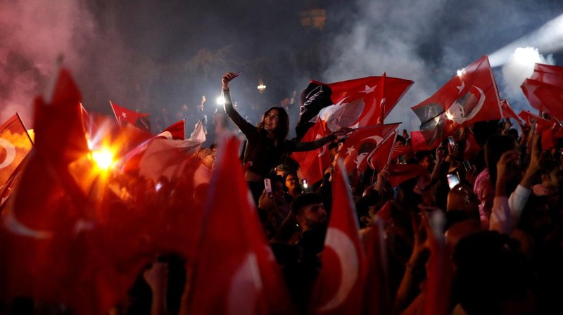 Pendukung Walikota Istanbul Ekrem Imamoglu dari oposisi utama Partai Rakyat Republik (CHP), merayakan hasil awal di depan Kota Metropolitan Istanbul (IBB) di Istanbul, Turki, Senin (1/4/2024). (REUTERS/Dilara Senkaya)