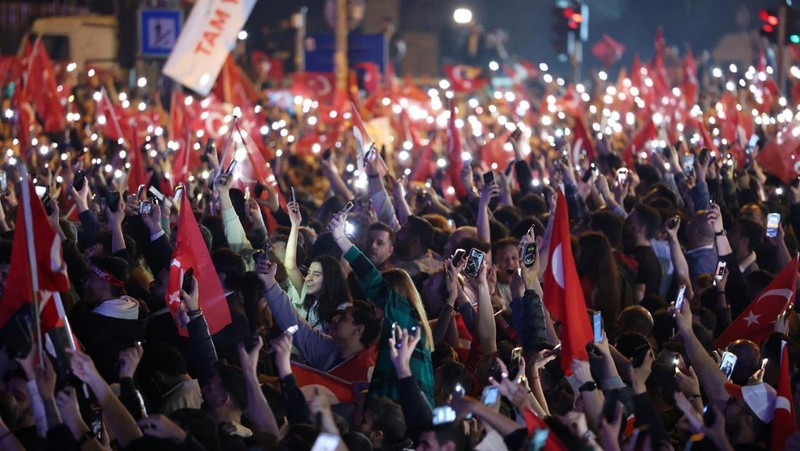 Pendukung Walikota Istanbul Ekrem Imamoglu dari oposisi utama Partai Rakyat Republik (CHP), merayakan hasil awal di depan Kota Metropolitan Istanbul (IBB) di Istanbul, Turki, Senin (1/4/2024). (REUTERS/Dilara Senkaya)