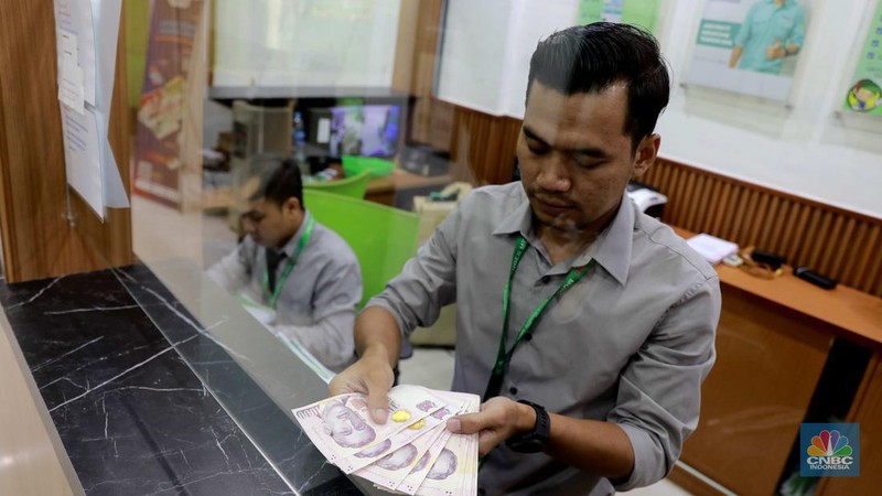 Penukaran uang di tempat penukaran uang atau Money Changer Tri Tunggal kawasan Blok M Plaza, Jakarta, Senin, (1/4/2024). (CNBC Indonesia/Muhammad Sabki)