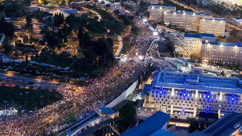 Puluhan ribu orang melakukan aksi unjuk rasa di depan gedung parlemen Israel di Yerusalem pada MInggu (31/3), menuntut Perdana Menteri Benjamin Netanyahu mundur dan pemilihan umum dini. (REUTERS/Ilan Rosenberg)
