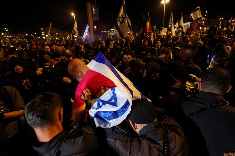 Puluhan ribu orang melakukan aksi unjuk rasa di depan gedung parlemen Israel di Yerusalem pada MInggu (31/3), menuntut Perdana Menteri Benjamin Netanyahu mundur dan pemilihan umum dini. (REUTERS/Ilan Rosenberg)