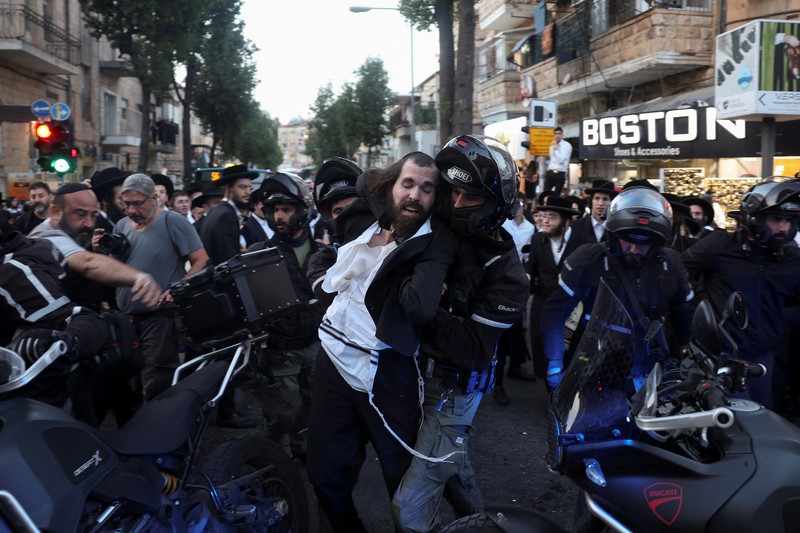 Puluhan ribu orang melakukan aksi unjuk rasa di depan gedung parlemen Israel di Yerusalem pada MInggu (31/3), menuntut Perdana Menteri Benjamin Netanyahu mundur dan pemilihan umum dini. (REUTERS/Ilan Rosenberg)