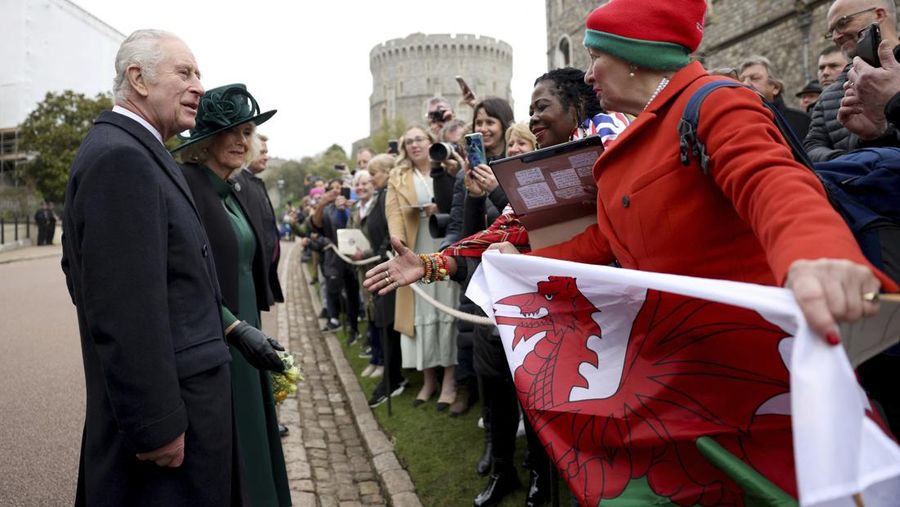 Raja Charles III dan Ratu Camilla dari Inggris menyapa masyarakat usai menghadiri Kebaktian Matins Paskah di Kapel St. George, Kastil Windsor, Inggris, Minggu (31/3/2024). (Hollie Adams/Pool Photo via AP)