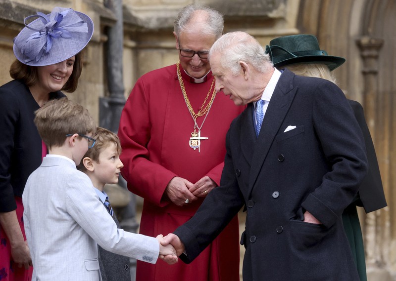 Raja Charles III dan Ratu Camilla dari Inggris menyapa masyarakat usai menghadiri Kebaktian Matins Paskah di Kapel St. George, Kastil Windsor, Inggris, Minggu (31/3/2024). (Hollie Adams/Pool Photo via AP)