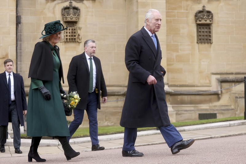 Raja Charles III dan Ratu Camilla dari Inggris menyapa masyarakat usai menghadiri Kebaktian Matins Paskah di Kapel St. George, Kastil Windsor, Inggris, Minggu (31/3/2024). (Hollie Adams/Pool Photo via AP)