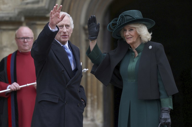 Raja Charles III dan Ratu Camilla dari Inggris menyapa masyarakat usai menghadiri Kebaktian Matins Paskah di Kapel St. George, Kastil Windsor, Inggris, Minggu (31/3/2024). (Hollie Adams/Pool Photo via AP)