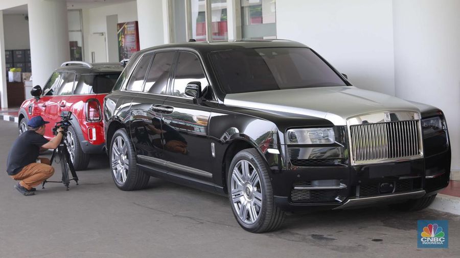 Dua unit mobil mewah sitaan kejagung Mini Cooper berwarna merah dan Rolls-Royce berwarna hitam di kawasan gedung Kejagung RI, Jakarta, Selasa, (2/4). (CNBC Indonesia/Muhammad Sabki)