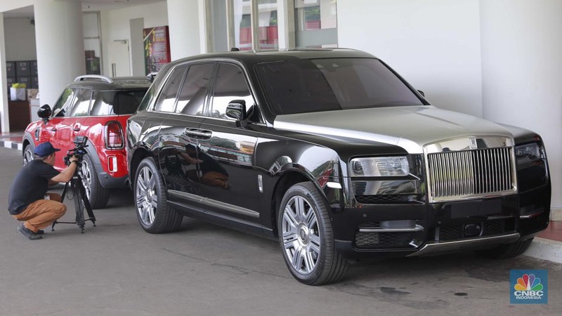 Dua unit mobil mewah sitaan kejagung Mini Cooper berwarna merah dan Rolls-Royce berwarna hitam di kawasan gedung Kejagung RI, Jakarta, Selasa, (2/4). (CNBC Indonesia/Muhammad Sabki)