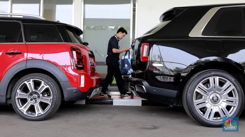 Dua unit mobil mewah sitaan kejagung Mini Cooper berwarna merah dan Rolls-Royce berwarna hitam di kawasan gedung Kejagung RI, Jakarta, Selasa, (2/4). (CNBC Indonesia/Muhammad Sabki)