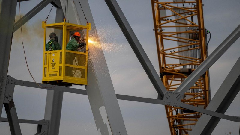 Puing-puing jembatan Francis Scott Key terletak di seberang dek kapal kargo Dali saat pekerjaan penyelamatan berlanjut, di Baltimore, Maryland, AS, 1 April 2024. (REUTERS/Julia Nikhinson)