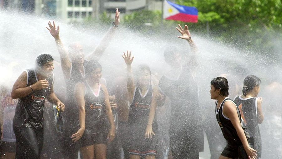 Warga menyiramkan air ke badan mereka pada saat musim panas di Filipina. (AP Photo/Aaron Favila)