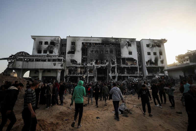 Warga Palestina memeriksa kerusakan di Rumah Sakit Al Shifa setelah pasukan Israel mundur dari Rumah Sakit dan area sekitarnya setelah operasi dua minggu, di tengah konflik yang sedang berlangsung antara Israel dan Hamas, di Kota Gaza 1 April 2024. (REUTERS/Dawoud Abu Alkas) TPX IMAGES OF THE DAY
