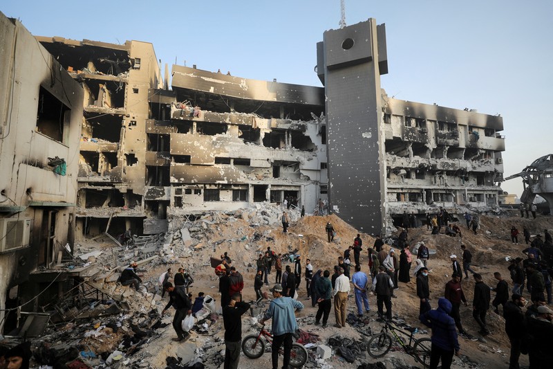 Warga Palestina memeriksa kerusakan di Rumah Sakit Al Shifa setelah pasukan Israel mundur dari Rumah Sakit dan area sekitarnya setelah operasi dua minggu, di tengah konflik yang sedang berlangsung antara Israel dan Hamas, di Kota Gaza 1 April 2024. (REUTERS/Dawoud Abu Alkas) TPX IMAGES OF THE DAY