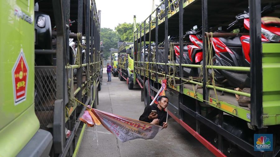 Pekerja mengecek ikatan kendaraan motor yang hendak dikirim melalui jasa pengiriman yang dibuka untuk Mudik Gratis 2024 di Terminal Pulogadung, Jakarta, Rabu (3/4/2024). (CNBC Indonesia/Muhammad Sabki)