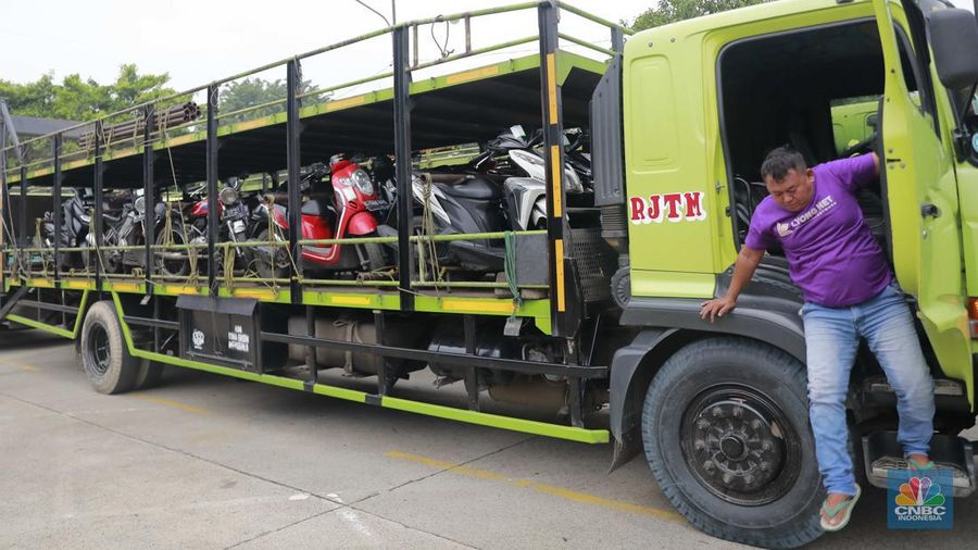 Pekerja mengecek ikatan kendaraan motor yang hendak dikirim melalui jasa pengiriman yang dibuka untuk Mudik Gratis 2024 di Terminal Pulogadung, Jakarta, Rabu (3/4/2024). (CNBC Indonesia/Muhammad Sabki)