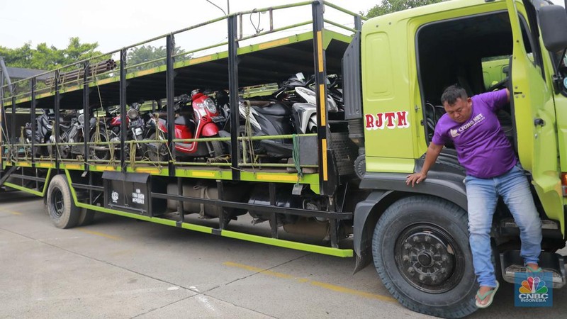 Pekerja mengecek ikatan kendaraan motor yang hendak dikirim melalui jasa pengiriman yang dibuka untuk Mudik Gratis 2024 di Terminal Pulogadung, Jakarta, Rabu (3/4/2024). (CNBC Indonesia/Muhammad Sabki)