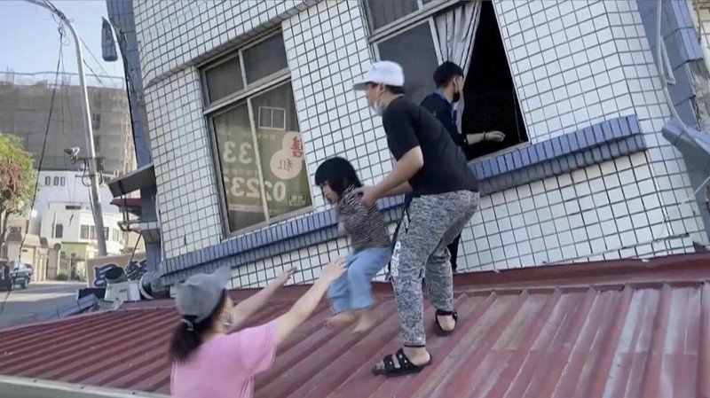 Warga menyelamatkan seorang anak dari bangunan yang runtuh sebagian di Hualien, Taiwan timur pada Rabu, 3 April 2024. (TVBS via AP)