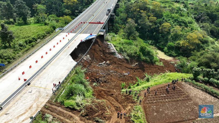 Foto udara menunjukkan sejumlah petugas mengevakuasi kendaaran roda empat yang terperosok akibat longsor di KM 64 tol, Bocimi, Sukabumi, Jawa Barat, Kamis, (4/4/2024). (CNBC Indonesia/Muhammad Sabki)