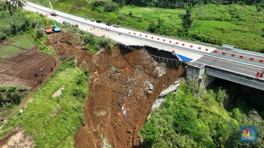 Foto udara menunjukkan sejumlah petugas mengevakuasi kendaaran roda empat yang terperosok akibat longsor di KM 64 tol, Bocimi, Sukabumi, Jawa Barat, Kamis, (4/4/2024). (CNBC Indonesia/Muhammad Sabki)