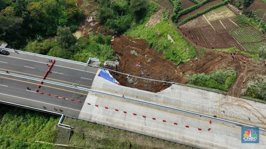 Warga mengamati kondisi jalan tol yang amblas di ruas tol Bocimi KM 64, Sukabumi, Jawa Barat, Kamis (4/4/2024). (CNBC Indonesia/Muhammad Sabki)