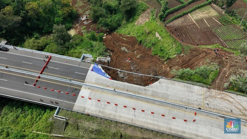 Warga mengamati kondisi jalan tol yang amblas di ruas tol Bocimi KM 64, Sukabumi, Jawa Barat, Kamis (4/4/2024). (CNBC Indonesia/Muhammad Sabki)