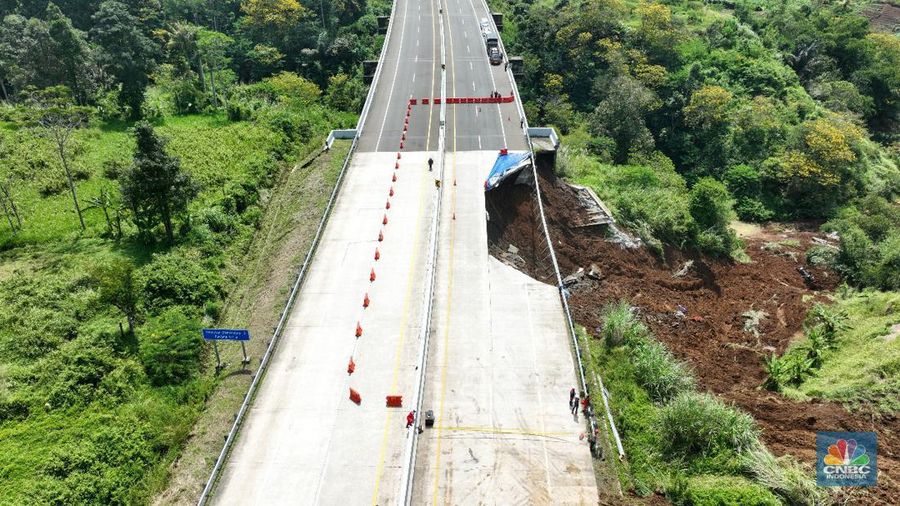 Sejumlah petugas mengevakuasi kendaaran roda empat yang terperosok akibat longsor di KM 64 tol, Bocimi, Sukabumi, Jawa Barat, Kamis, (4/4/2024). (CNBC Indonesia/Muhammad Sabki)