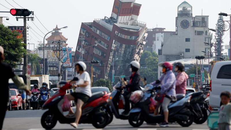 Seorang wanita membawa barang dagangan dari toko sepeda di gedung yang rusak saat orang memindahkan barang dagangan dan barang berharga ke luar gedung, pasca gempa, di Hualien, Taiwan, 4 April 2024. (REUTERS/Carlos Garcia Rawlins)