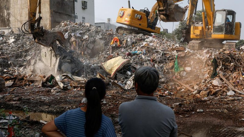 Seorang wanita membawa barang dagangan dari toko sepeda di gedung yang rusak saat orang memindahkan barang dagangan dan barang berharga ke luar gedung, pasca gempa, di Hualien, Taiwan, 4 April 2024. (REUTERS/Carlos Garcia Rawlins)