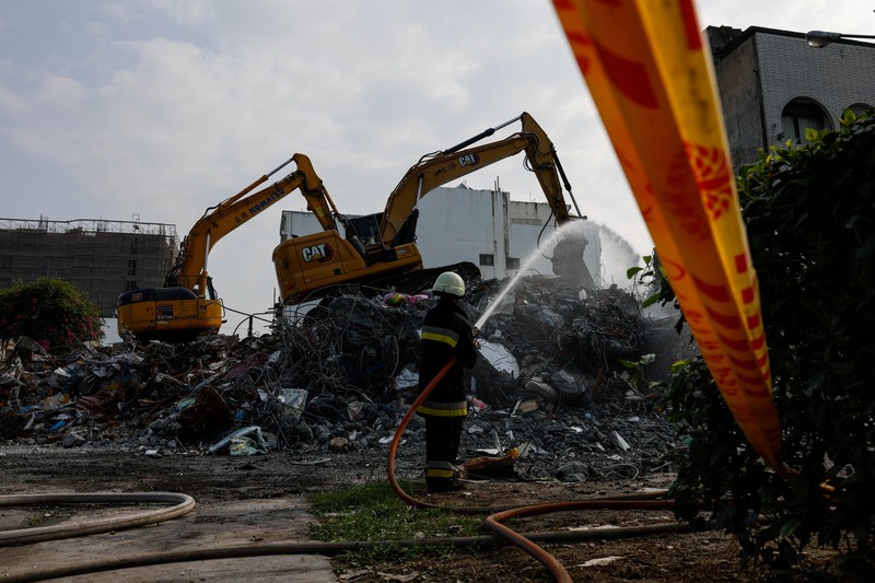 Orang-orang mengendarai sepeda motor di dekat lokasi bangunan runtuh pasca gempa, di Hualien, Taiwan 4 April 2024. (REUTERS/Carlos Garcia Rawlins)