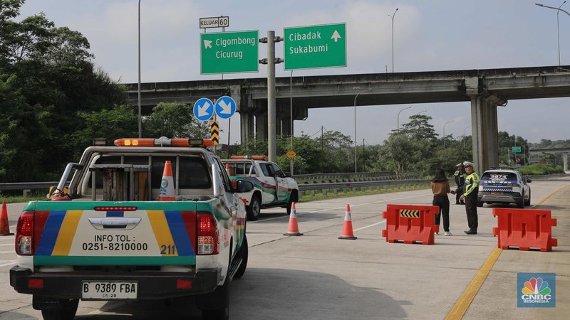 Sejumlah petugas betugas berjaga mengalihkan jalan tol di exit tol Bogor Ciawi, Jawa Barat, Kamis, (4/4/2024). Akses exit tol ditutup dari arah Jakarta ke Sukabumi maupun sebaliknya. (CNBC Indonesia/Muhammad Sabki)