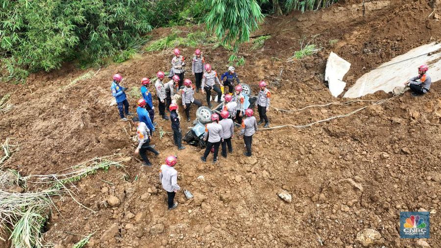 Foto udara menunjukkan sejumlah petugas mengevakuasi kendaaran roda empat yang terperosok akibat longsor di KM 64 tol, Bocimi, Sukabumi, Jawa Barat, Kamis, (4/4/2024). (CNBC Indonesia/Muhammad Sabki)