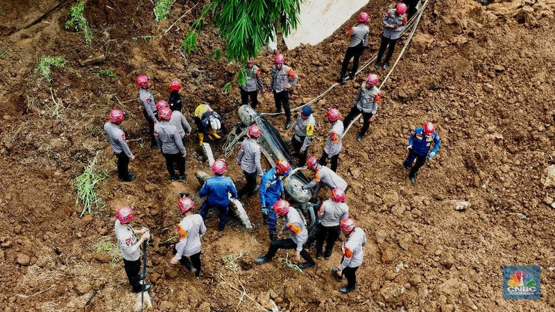 Foto udara menunjukkan sejumlah petugas mengevakuasi kendaaran roda empat yang terperosok akibat longsor di KM 64 tol, Bocimi, Sukabumi, Jawa Barat, Kamis, (4/4/2024). (CNBC Indonesia/Muhammad Sabki)