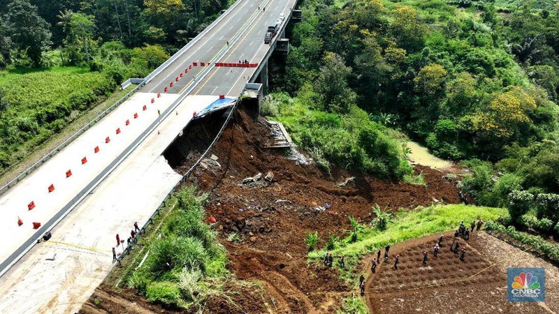 Foto udara menunjukkan sejumlah petugas mengevakuasi kendaaran roda empat yang terperosok akibat longsor di KM 64 tol, Bocimi, Sukabumi, Jawa Barat, Kamis, (4/4/2024). (CNBC Indonesia/Muhammad Sabki)