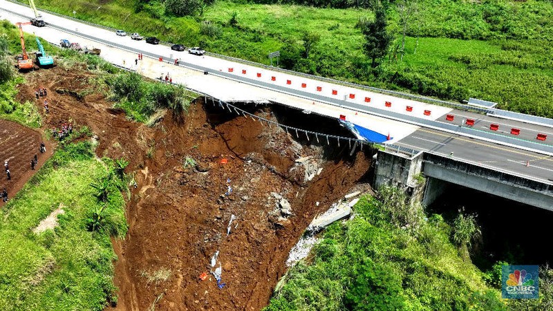 Sejumlah petugas mengevakuasi kendaaran roda empat yang terperosok akibat longsor di KM 64 tol, Bocimi, Sukabumi, Jawa Barat, Kamis, (4/4/2024). (CNBC Indonesia/Muhammad Sabki)