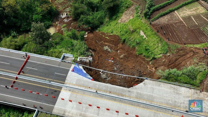 Sejumlah petugas mengevakuasi kendaaran roda empat yang terperosok akibat longsor di KM 64 tol, Bocimi, Sukabumi, Jawa Barat, Kamis, (4/4/2024). (CNBC Indonesia/Muhammad Sabki)