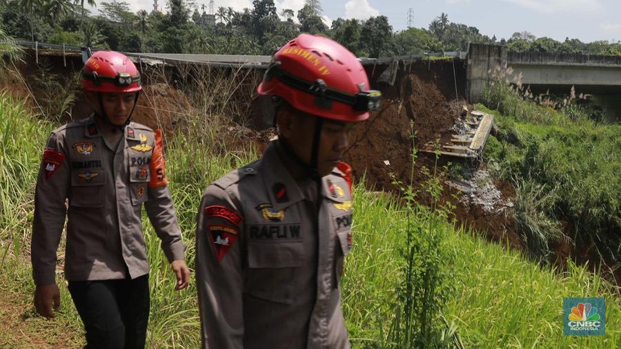 Warga mengamati kondisi jalan tol yang amblas di ruas tol Bocimi KM 64, Sukabumi, Jawa Barat, Kamis (4/4/2024). (CNBC Indonesia/Muhammad Sabki)