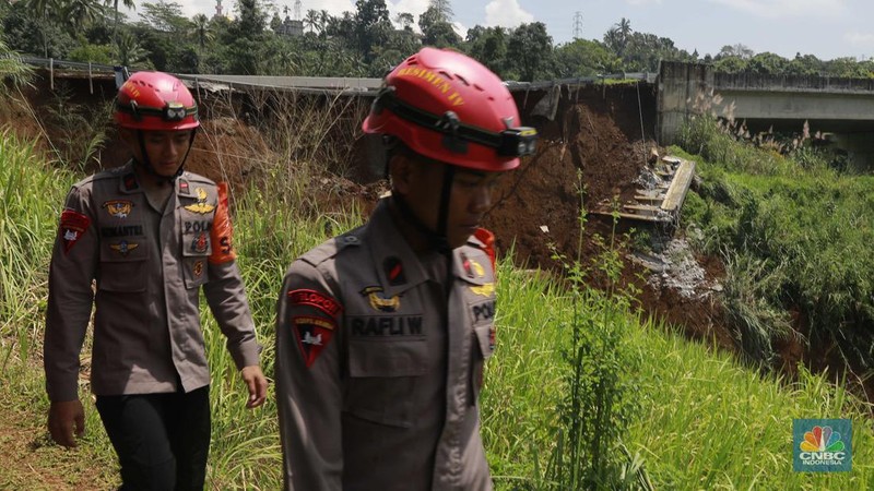 Warga mengamati kondisi jalan tol yang amblas di ruas tol Bocimi KM 64, Sukabumi, Jawa Barat, Kamis (4/4/2024). (CNBC Indonesia/Muhammad Sabki)
