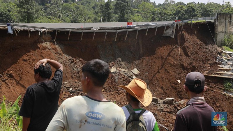 Warga mengamati kondisi jalan tol yang amblas di ruas tol Bocimi KM 64, Sukabumi, Jawa Barat, Kamis (4/4/2024). (CNBC Indonesia/Muhammad Sabki)