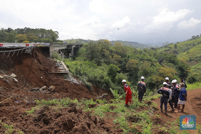 Warga mengamati kondisi jalan tol yang amblas di ruas tol Bocimi KM 64, Sukabumi, Jawa Barat, Kamis (4/4/2024). (CNBC Indonesia/Muhammad Sabki)