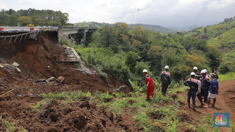 Warga mengamati kondisi jalan tol yang amblas di ruas tol Bocimi KM 64, Sukabumi, Jawa Barat, Kamis (4/4/2024). (CNBC Indonesia/Muhammad Sabki)