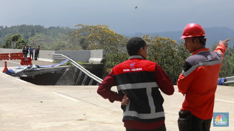 Warga mengamati kondisi jalan tol yang amblas di ruas tol Bocimi KM 64, Sukabumi, Jawa Barat, Kamis (4/4/2024). (CNBC Indonesia/Muhammad Sabki)