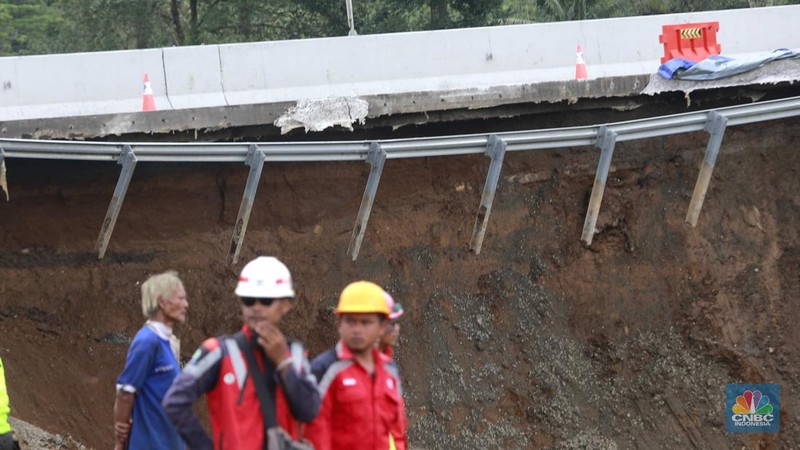 Sejumlah petugas mengevakuasi kendaaran roda empat yang terperosok akibat longsor di KM 64 tol, Bocimi, Sukabumi, Jawa Barat, Kamis, (4/4/2024). (CNBC Indonesia/Muhammad Sabki)